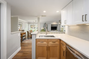 A modern kitchen with wooden cabinets, a stainless steel sink, and a large island. - Cozy 1BR King suite in Palmetto Dunes, Hilton Head Island, perfect for couples! (Hilton Head Island)