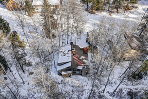 A house surrounded by snow-covered trees. - Serene Mountain Retreat with Private Beach Access (McCall)