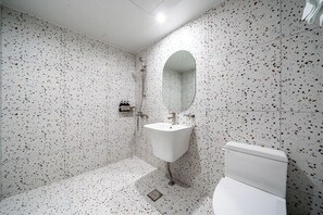 Tweepersoonskamer | Badkamer | Een aparte badkuip en douche, een haardroger, badjassen, pantoffels