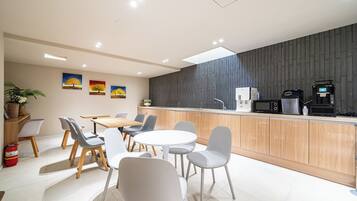 Cocina moderna con isla central, zona de comedor con sillas y microondas.