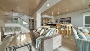 A modern living room with a sofa, chairs, a dining table, and a staircase. - Oceanfront La Selva Beach Home w/ Fireplace, Views & Direct Beach Access Sand Castle by Avantstay (Watsonville)