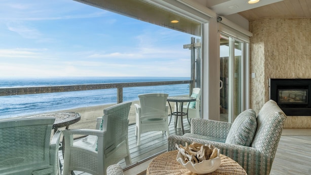 A balcony with a view of the ocean, furnished with chairs and a table, and a fireplace. - Oceanfront La Selva Beach Home w/ Fireplace, Views & Direct Beach Access Sand Castle by Avantstay (Watsonville)