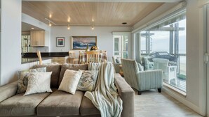A living room with a sofa, chairs, a dining table, and a large window overlooking the ocean. - Oceanfront La Selva Beach Home w/ Fireplace, Views & Direct Beach Access Sand Castle by Avantstay (Watsonville)
