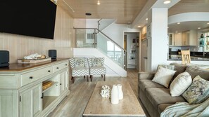 A modern living room with a wooden floor, a sofa, a coffee table, and a TV.