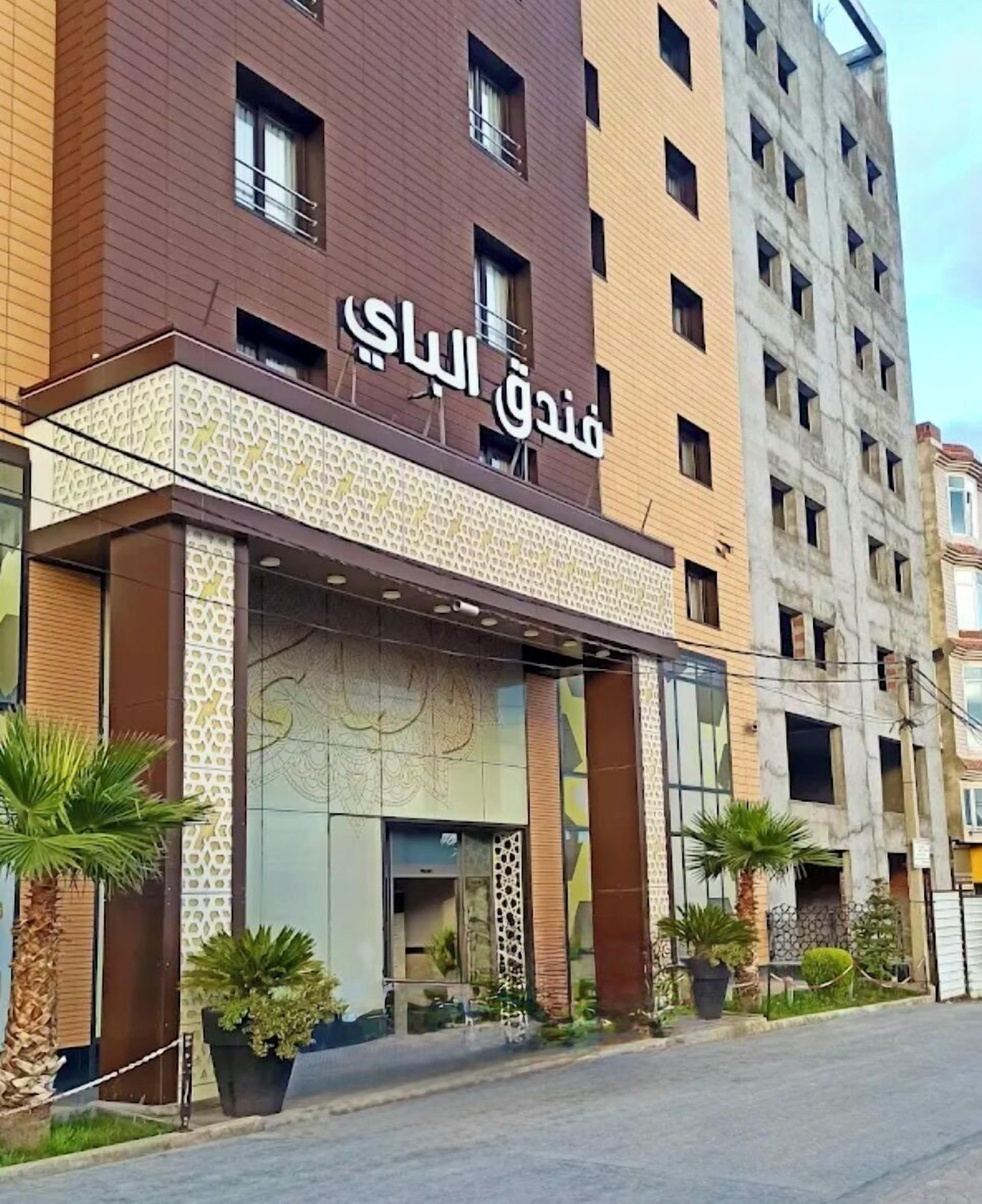 A modern hotel with a prominent entrance, large windows, and decorative panels.