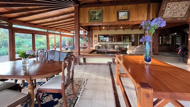 Uma sala de jantar espaçosa com uma mesa e cadeiras de madeira, uma janela grande e vista para o exterior.