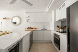 A modern kitchen with white cabinetry, a built-in oven, and a stainless steel refrigerator. - Headland Views 2 - Leafy Retreat (Noosa)