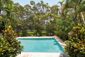 A rectangular swimming pool surrounded by lush greenery and trees. - Headland Views 2 - Leafy Retreat (Noosa)