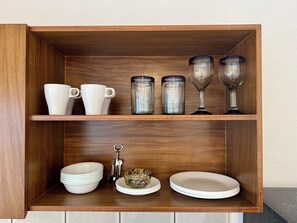A wooden shelf with white cups, clear glassware, and plates. - Wonderful 3-bedroom building with AC in Puerto Vallarta (Puerto Vallarta)