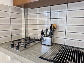 A kitchen with a gas stove, a stainless steel utensil holder, and a stainless steel grill. - Wonderful 3-bedroom building with AC in Puerto Vallarta (Puerto Vallarta)