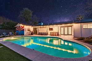 A swimming pool with a curved edge, a covered patio area with outdoor furniture, and a starry night sky. - Diamond Oasis - Old Town, ASU - Heated Pool, Spa (Scottsdale)