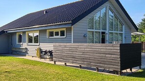 A single-story house with a dark roof, large windows, and a wooden fence. - Gorgeous home in Tarm with sauna (Tarm)