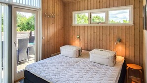A bedroom with a bed, two bedside tables, a window, and a view of the outdoors. - Gorgeous home in Tarm with sauna (Tarm)