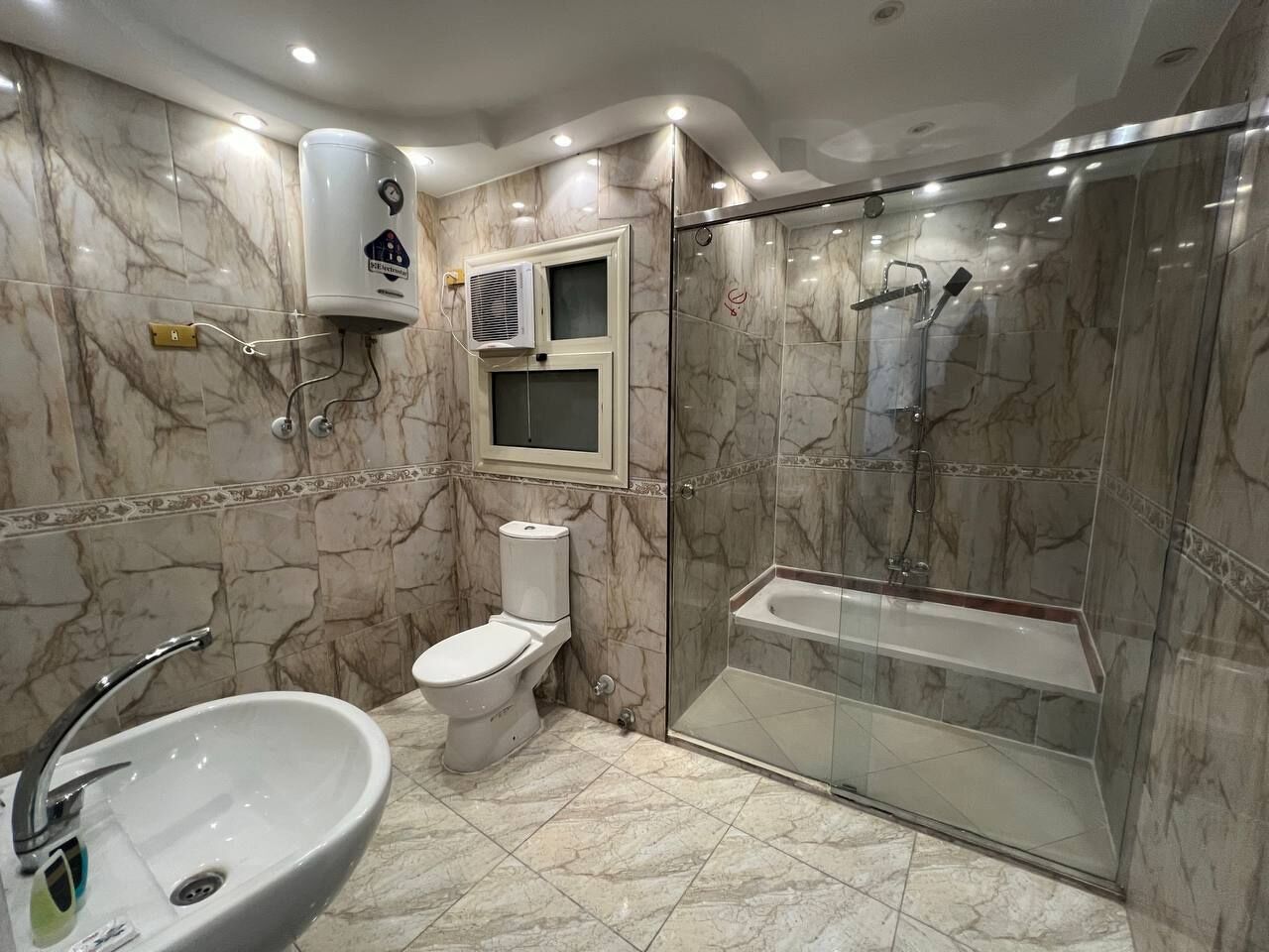 Habitación triple Deluxe | Baño | Ducha y bañera combinadas y cabezal de ducha tipo lluvia