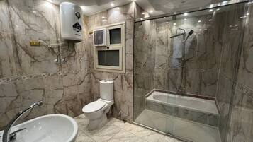 Habitación triple Deluxe | Baño | Ducha y bañera combinadas y cabezal de ducha tipo lluvia