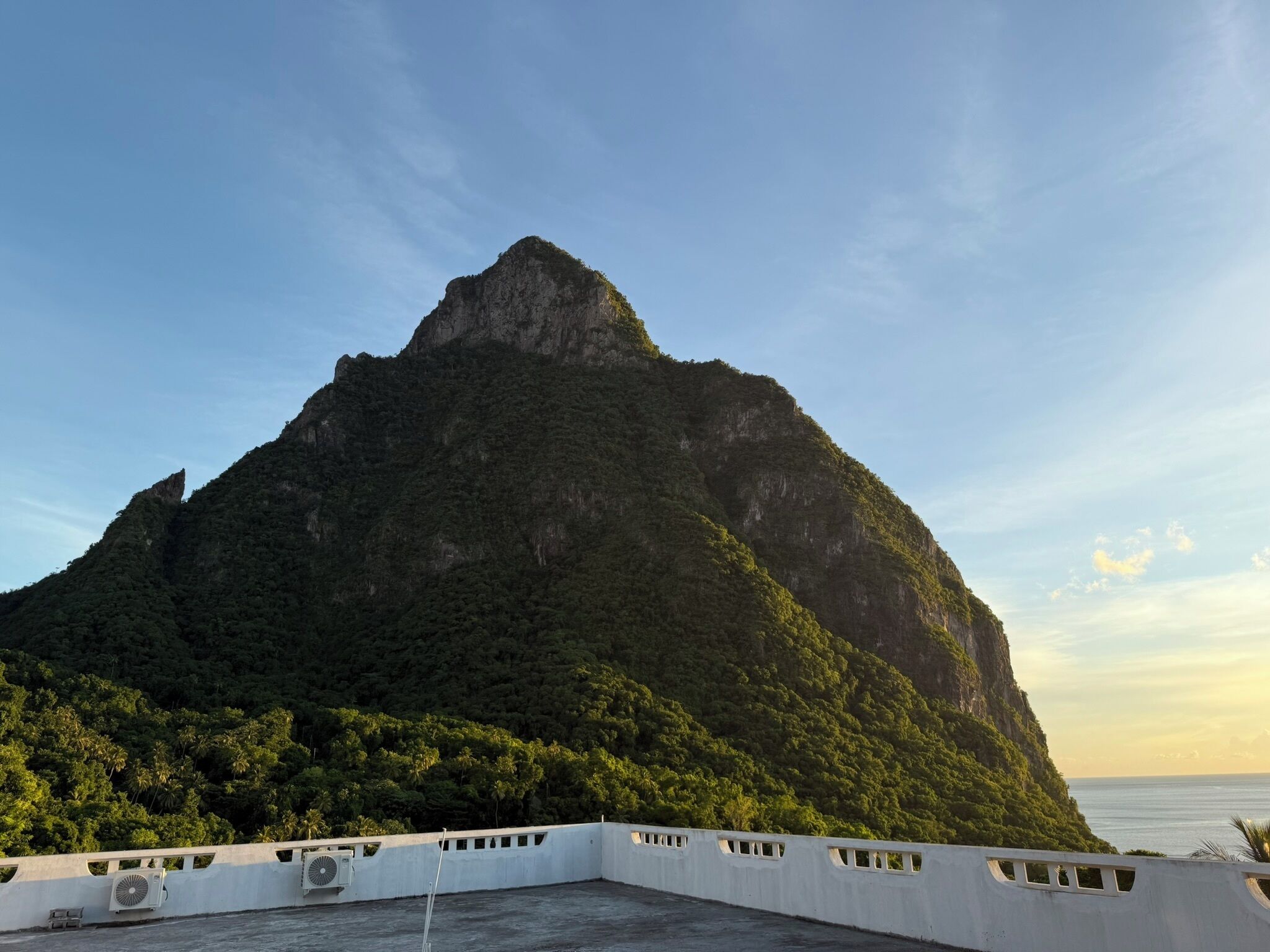 A mountain with a white structure in the foreground.