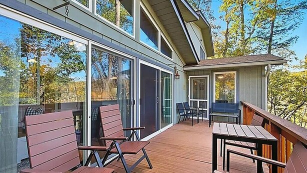 A modern outdoor deck with wooden furniture and large windows. - Mountain Retreat Near Bryce Resort. Game Rm. Sleeps 8 Family and Dog Friendly! (Basye)