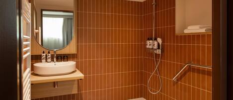 A bathroom with a shower, toilet, and sink.