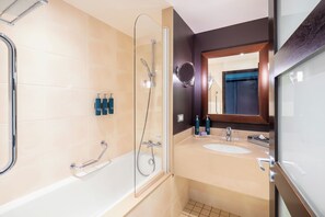 Un baño moderno con bañera, ducha y tocador con espejo.