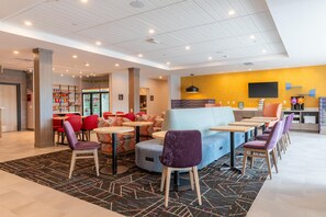 A modern hotel lobby with a seating area, a bar, and a refreshment station. - Home2 Suites By Hilton North Attleboro (North Attleboro)