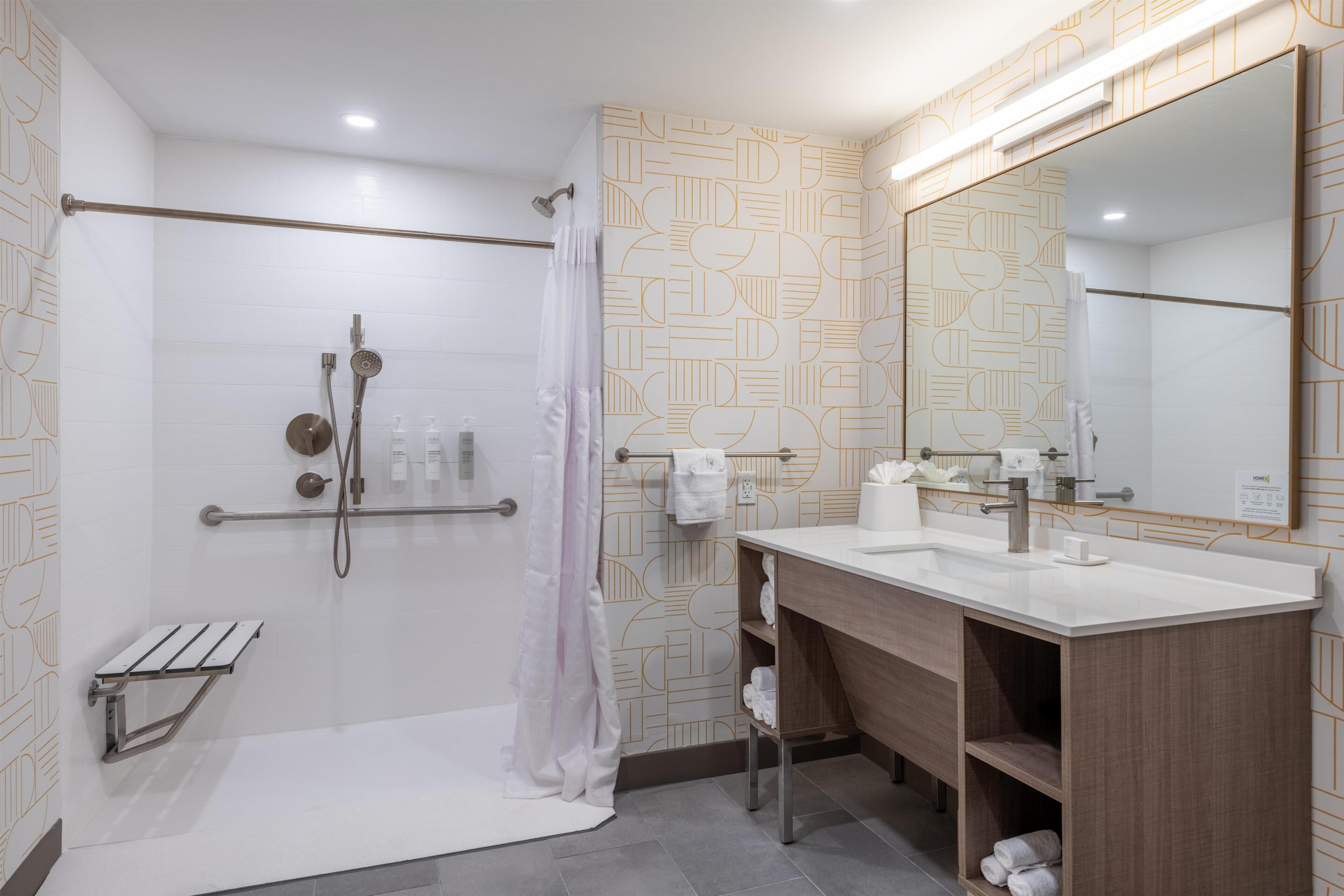 A modern bathroom with a shower, toilet, and sink.