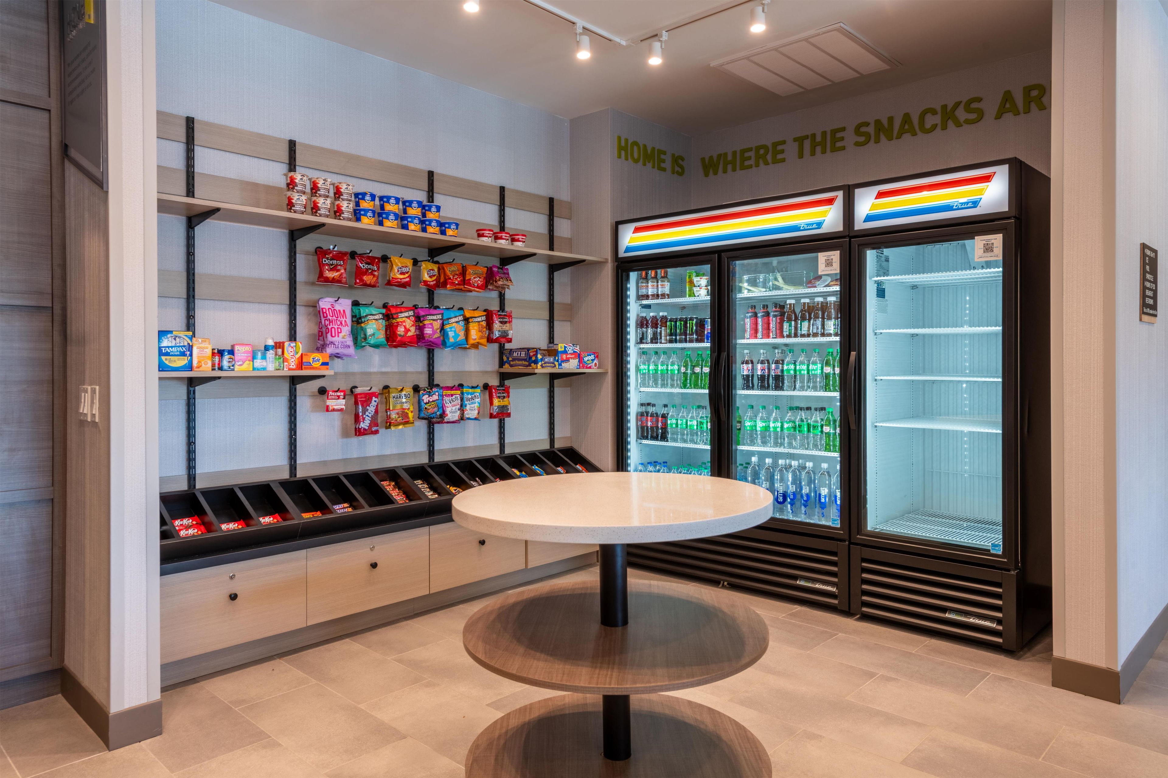 Ein Snackbereich mit Regalen voller Snacks und einem Kühlschrank für Getränke.
