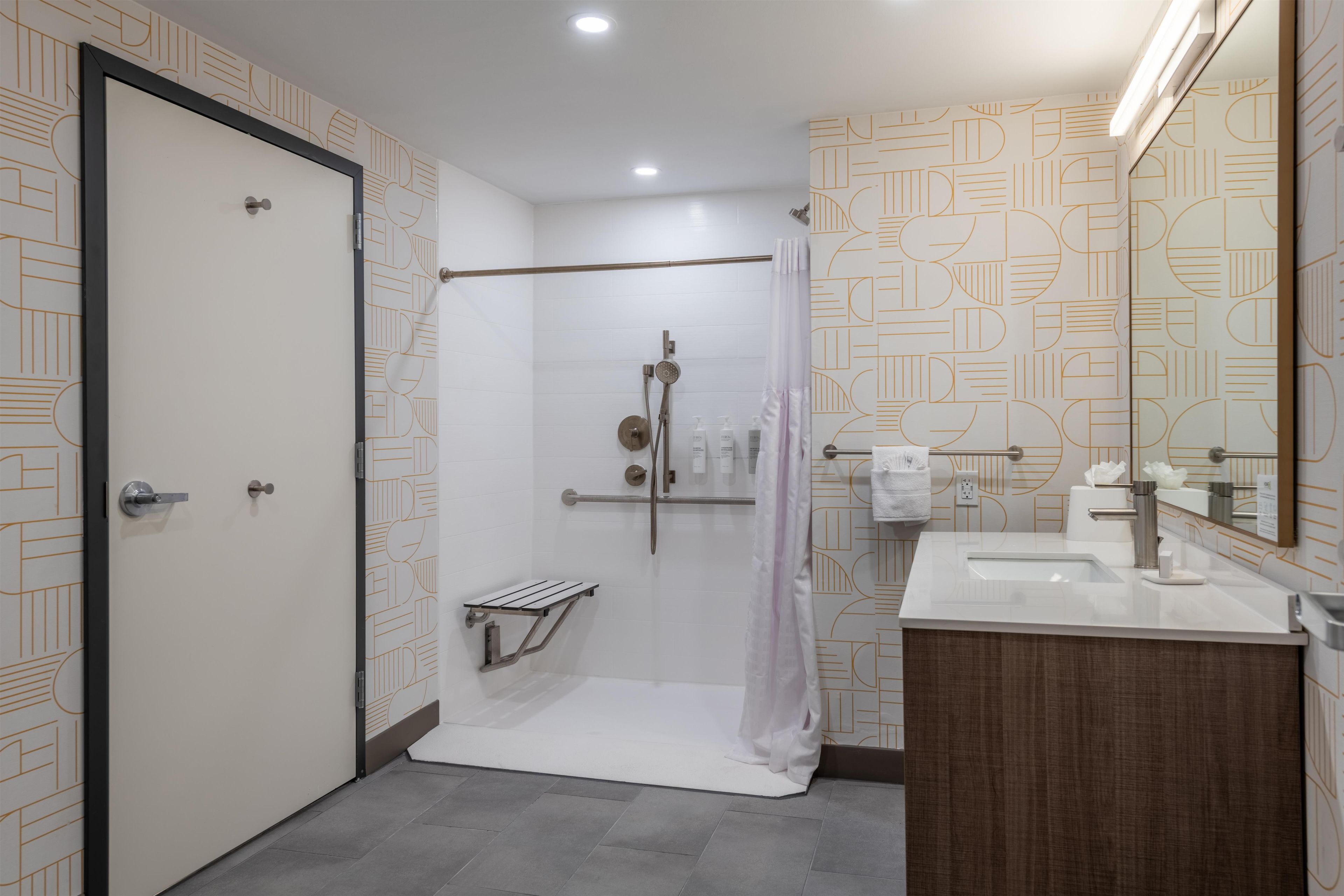 A modern bathroom with a shower, a toilet, and a sink.