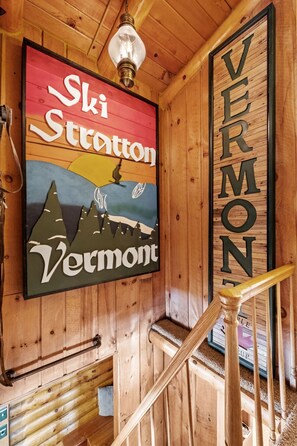 A wooden interior with a sign reading "Ski Stratton Vermont" and a wooden staircase.