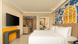 A hotel room with a bed, a TV, a bathroom, and a wardrobe.