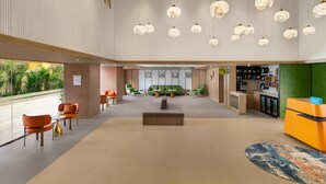 A spacious lobby with a reception desk, seating area, and a green sofa.