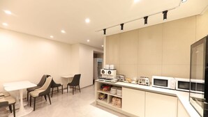 A modern kitchen with a dining area, equipped with a microwave, toaster, and coffee maker. - HOTEL SIGNATURE GWANGJU (Gwangju)
