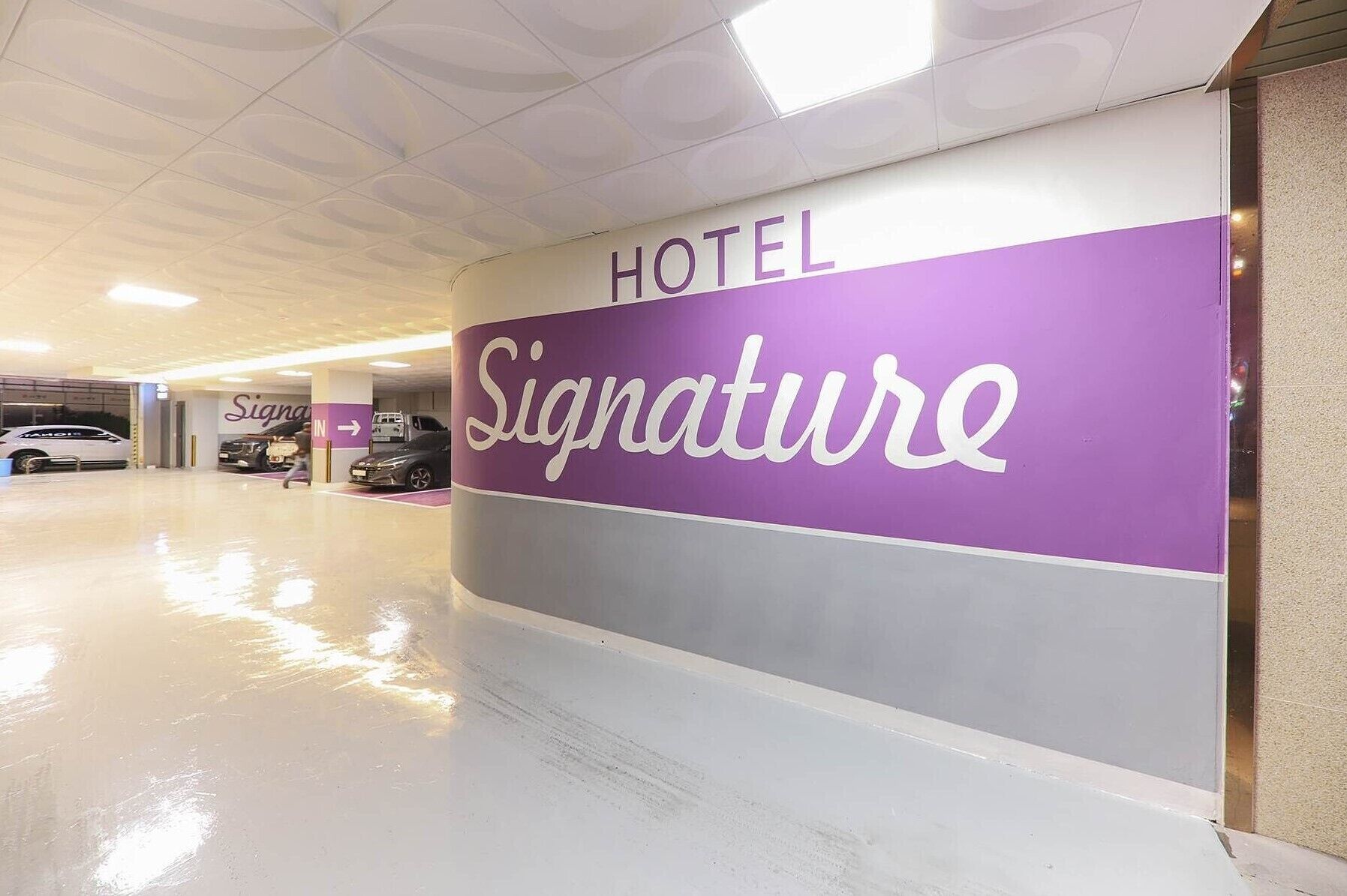 Ein Hotel Eingang mit einem 'Signature'-Schild und einem 'Hotel'-Schild darüber.