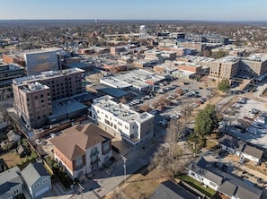 An aerial view of a downtown area with various buildings, streets, and parking lots.
