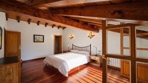 A bedroom with a wooden ceiling, a bed, a nightstand, and a wall-mounted light fixture. - La Franca beach, garden and WiFi - Casa Freya (Franca, La)