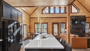 Una cucina moderna con isola centrale, elettrodomestici neri e finiture in legno.