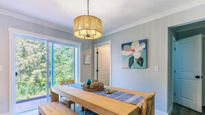 Un comedor con una mesa de madera, banco y una lámpara colgante.