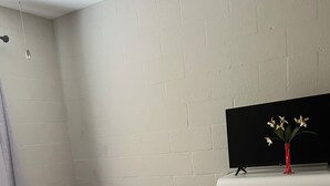 Ein Schlafzimmer mit einem Bett, einer Kommode und einem Fernseher auf einem Schrank.