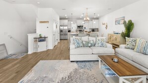 A spacious living room with a large sofa, a coffee table, and a patterned rug. - Gulfview Paradise in Lost Key (Pensacola)