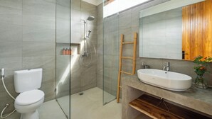 Ein modernes Badezimmer mit Duschkabine aus Glas, einer weißen Toilette und einem Badezimmer-Einbau mit Waschbecken.