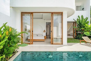A modern house with a glass-enclosed bedroom, a pool, and lush greenery. - Tropical Modern Villa Amaya by OriVista (Pecatu)