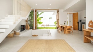 Ein modernes Interieur mit Treppe, Essbereich und Blick auf einen Garten.