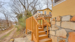 A wooden staircase leading to a stone building with a yellow exterior. - Boat & Fish! 1950s Rockaway Beach Cabin w/ Hot Tub (Rockaway Beach)