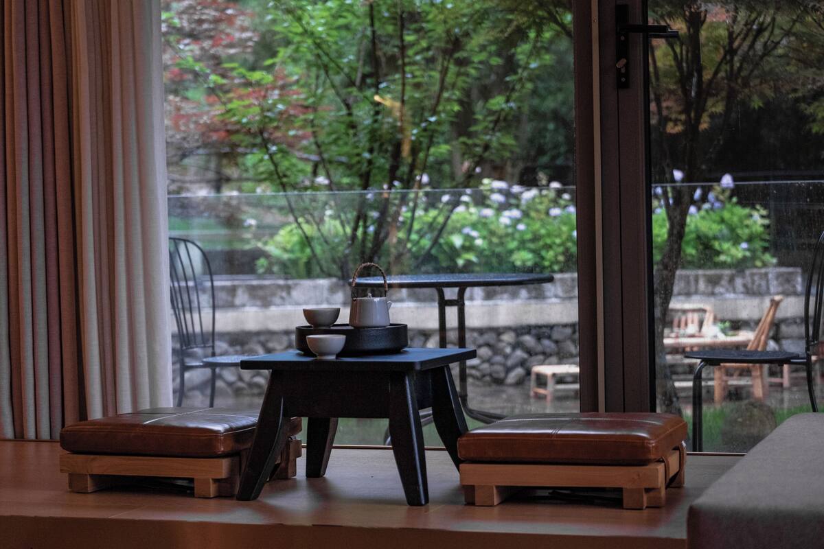 Una habitación moderna con vista a un jardín a través de un ventanal.