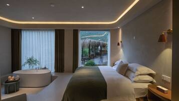 A modern bedroom with a large bed, a bathtub, and a view of a thatched-roof structure outside.
