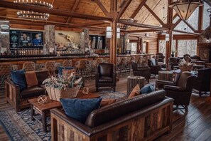 A rustic interior with wooden furniture, a bar area, and stone walls. - Gatlinburg New Year’s Week Resort Villa with Mountain Views (Gatlinburg)