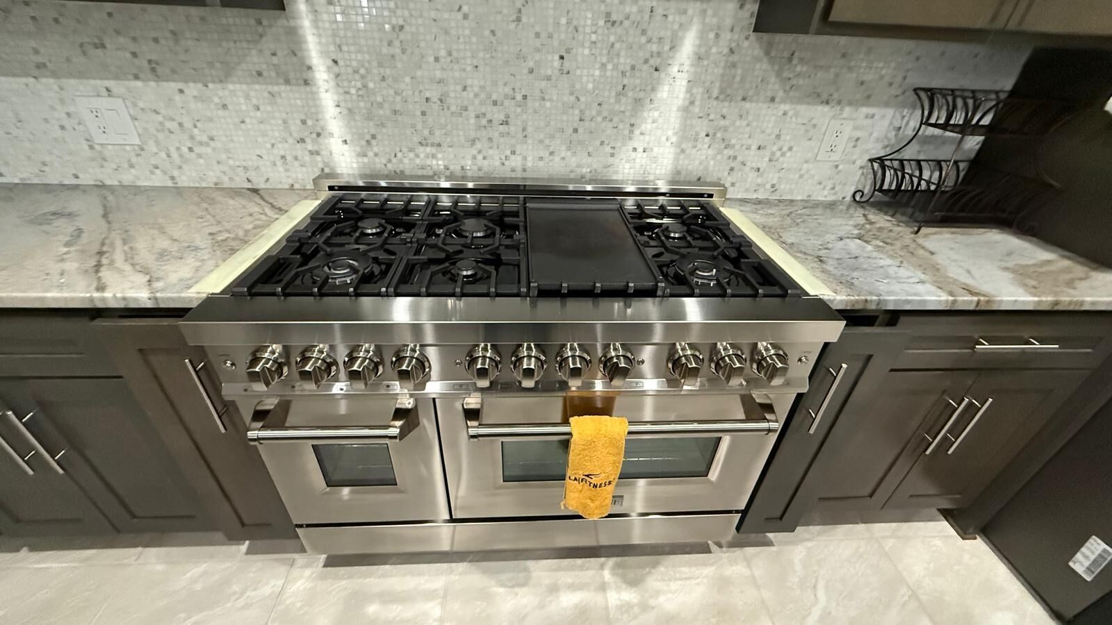 Una cocina con estufa de acero inoxidable, horno y dos hornos adicionales.
