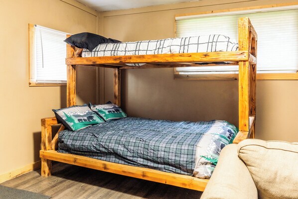 A bunk bed with a wooden frame, two pillows, and a checkered blanket. - Tranquil dry cabin in lovely Hope perfect for relaxing getaway (Hope)