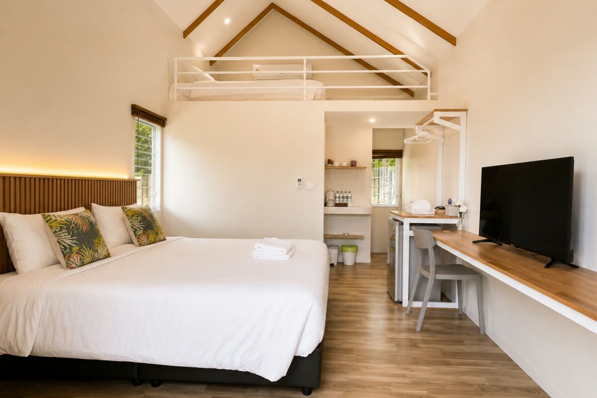 Une chambre avec un lit superposé, un bureau et un téléviseur.