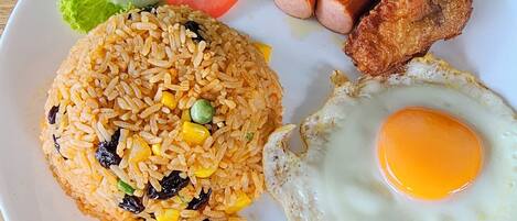 A plate of fried rice, a fried egg, and a side of vegetables and meat.