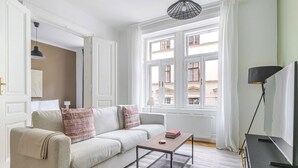 A well-lit living room with a sofa, a coffee table, and a television. - Blueground | Neubau, view, nr Museumsquartier (Vienna)